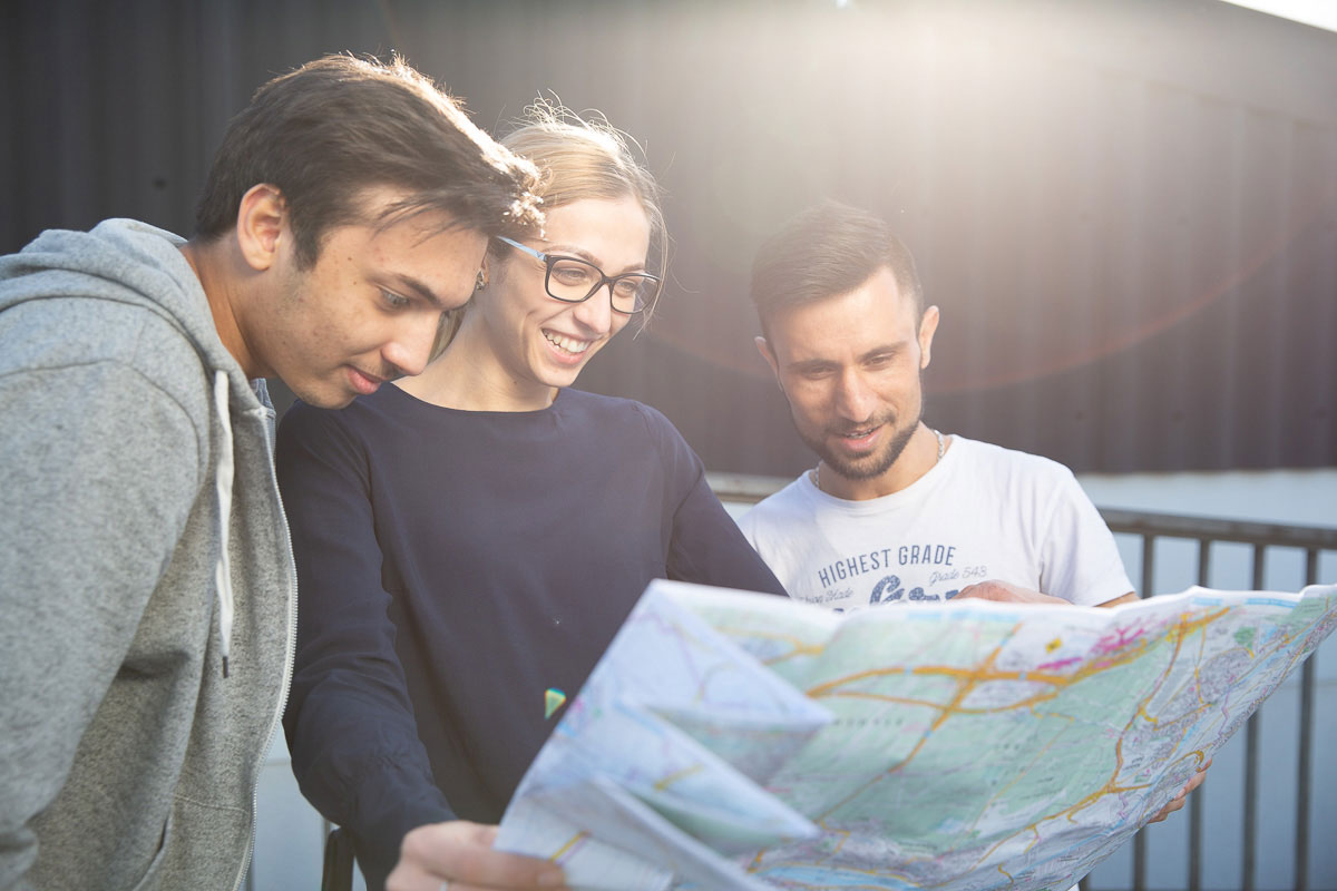 3 Personen schauen auf eine Karte